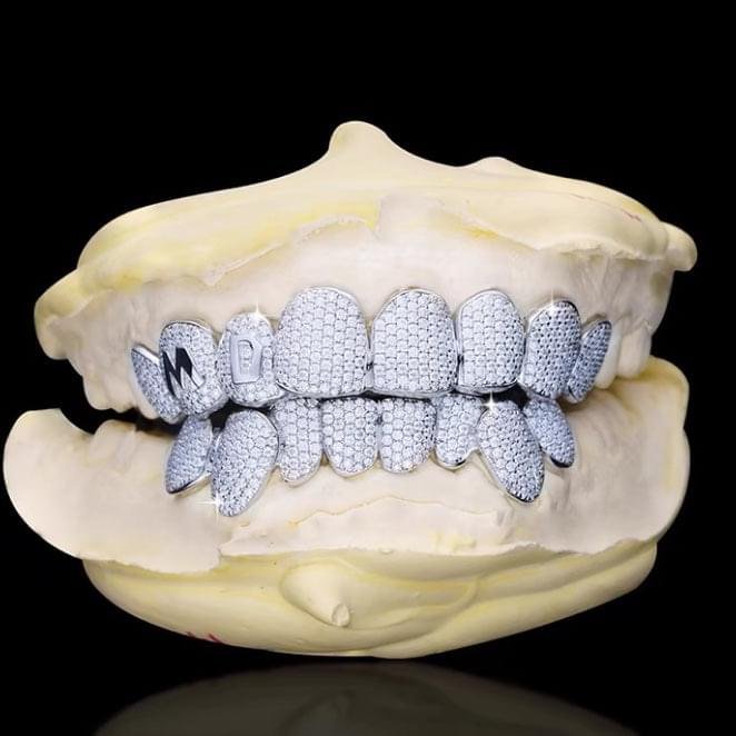 Main image: "S925 sterling silver 10X10 pavé moissanite grillz full set on dental mold" Detail shot 1: "Close-up of 10X10 moissanite stones in pavé setting on silver grillz" Detail shot 2: "Full set iced out moissanite grillz showing upper and lower teeth coverage" Lifestyle image: "Hip hop luxury moissanite grillz worn showing brilliant sparkle" Side view: "Side angle of S925 silver moissanite grillz showing stone coverage and fit"